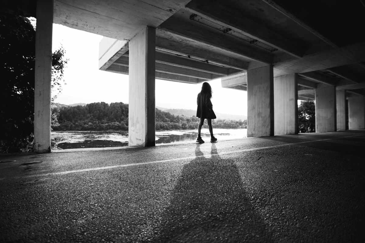 grayscale photography of woman in a parking lot