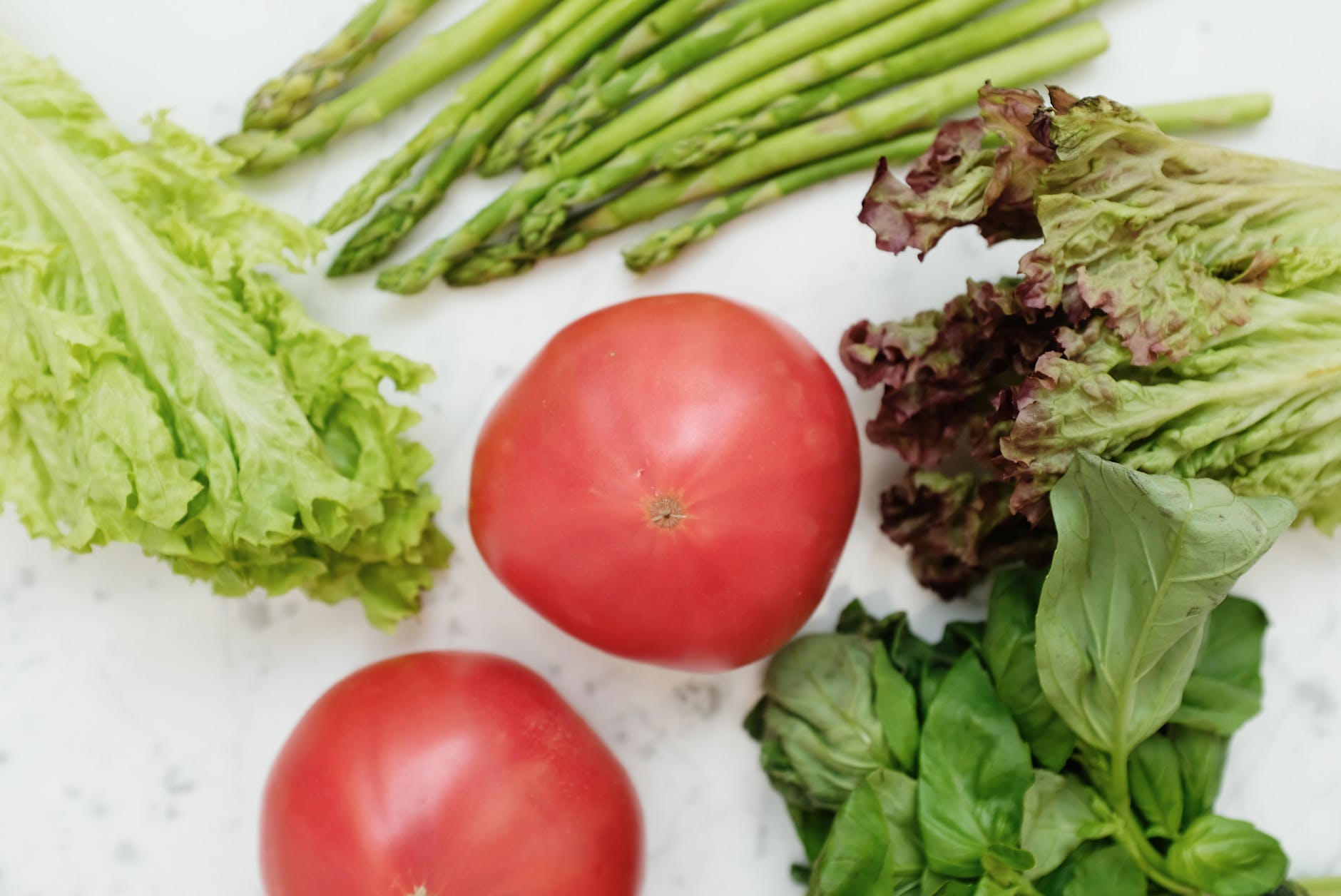 red tomatoes beside green vegetables